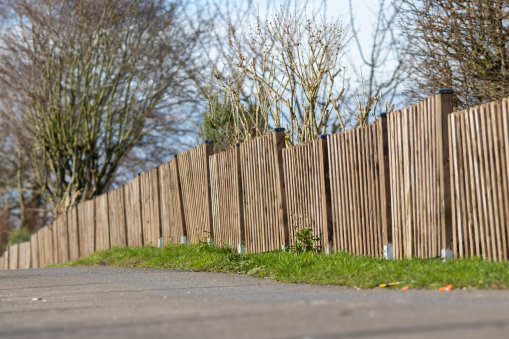 landscape-shot-brown-wooden-fence-mini-forest-with-clear-blue-sky